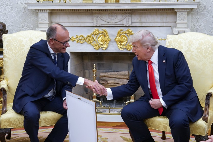 epa12158328 German Chancellor Friedrich Merz (L) presents US President Donald J Trump with what he said is the birth certificate of Trump&#039;s grandfather, &#039;Born in 1869,&#039; as they meet at  ...