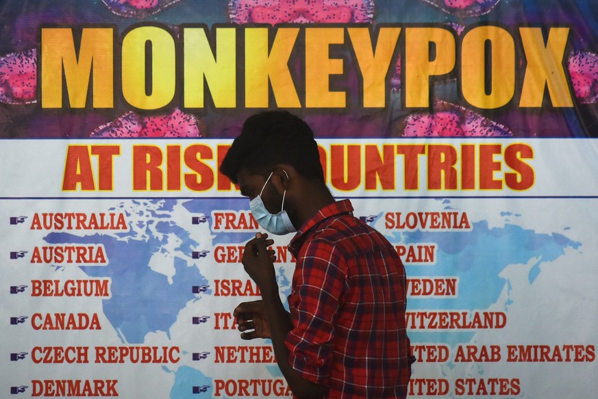 epa10074095 An Indian health worker walks in front of a list of high-risk countries for the Monkeypox virus, as India reported the first case of Monkeypox in the WHO South-East Asia Region, at Chennai ...