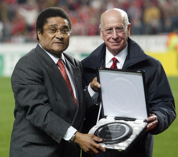 Former soccer star Eusebio, left, receives a UEFA trophy honouring soccer greats by another soccer legend Sir Bobby Charlton during half-time of the Champions League Group D soccer match between Benfi ...