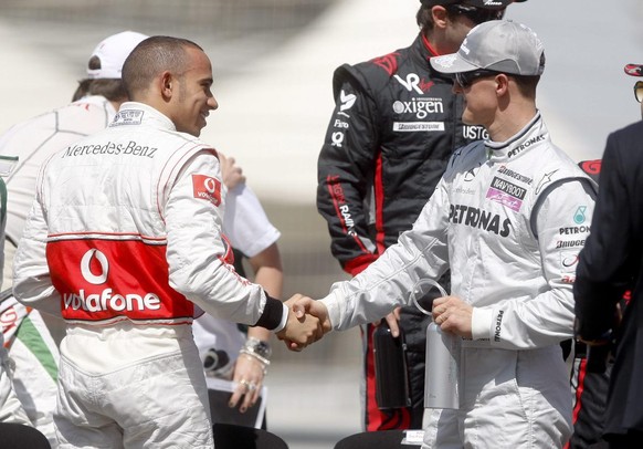 epa02078835 British Formula One driver Lewis Hamilton (L) of McLaren Mercedes greets German Formula One driver Michael Schumacher (R) of Mercedes GP before the official 2010 Formula 1 drivers photosho ...