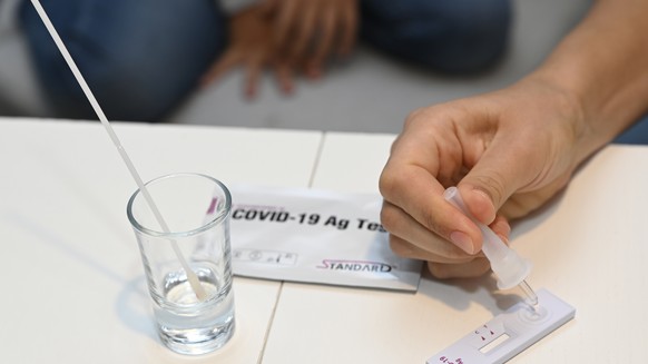 FILE - A mother tests her daughter with a Corona antigen self-test before starting school in Trencianske Stankovce, Slovakia, Oct. 4, 2021. New coronavirus cases soared to a new record high, with some ...