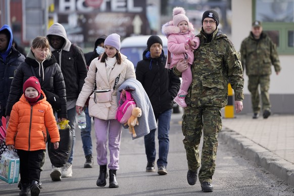Refugees from Ukraine cross into Poland at the Medyka crossing, Tuesday, March 1, 2022. Ambassadors from dozens of countries on Monday backed a proposal demanding that Russia halt its attack on Ukrain ...