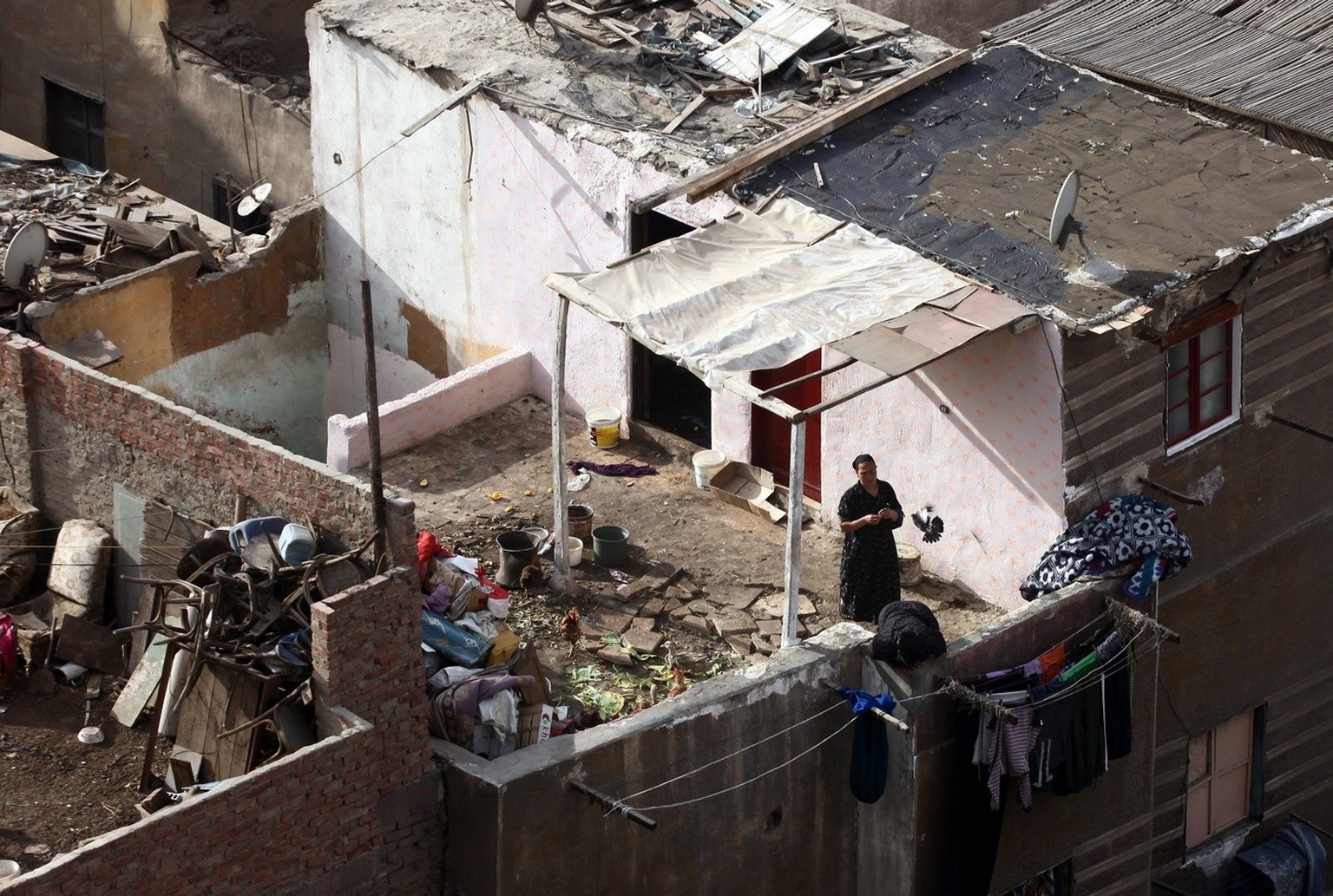 epa03584511 A woman looks from her balcony in the slum residents Ramlet Bulaq&#039;s in Cairo, Egypt, 14 February 2013. Ramlet Bulaq&#039;s residents live in run-down shacks and lack basic facilities, ...