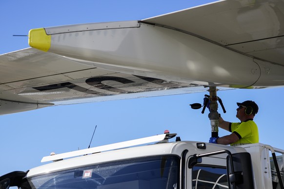 Ein Mann der Firma Skytanking fuellt den Tank eines Swiss International Air Lines Flugzeugs mit dem Treibstoff Kerosin auf, aufgenommen am Donnerstag, 23. April 2026 auf dem Rollfeld am Flughafen Zuer ...