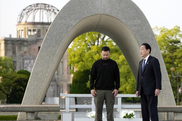 epa10643146 Ukrainian President Volodymyr Zelensky and Japanese Prime Minister Fumio Kishida have a talk after laying flowers in front of the Cenotaph for the Victims of the Atomic Bomb at the Hiroshi ...