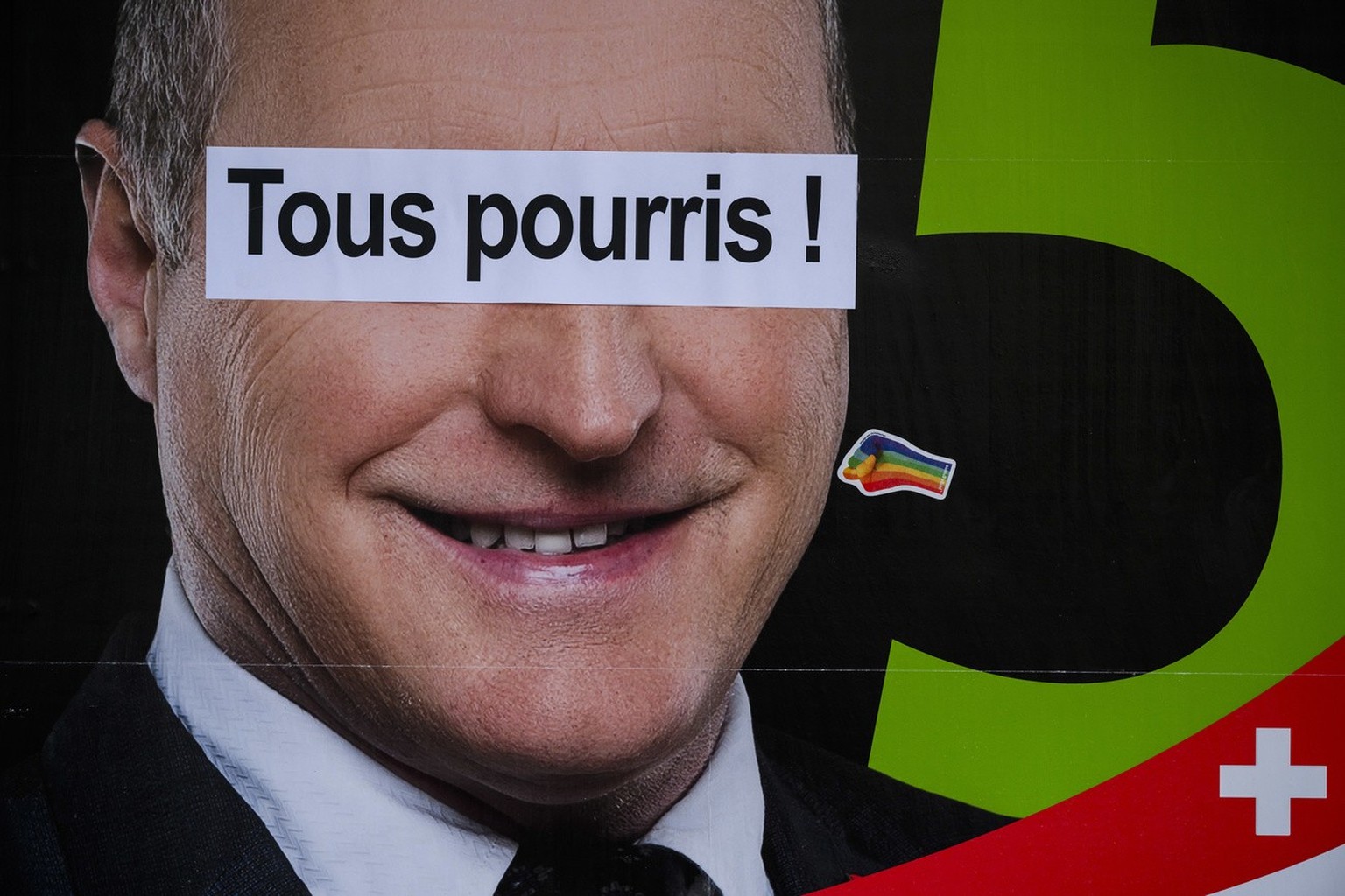 Un bandeau &quot;Tous pourris!&quot; cole sur une affiche du candidat fribourgeois UDC Pierre-Andre Page, candidat pour le Conseil national et le Conseil des Etats lors des prochaines elections federa ...