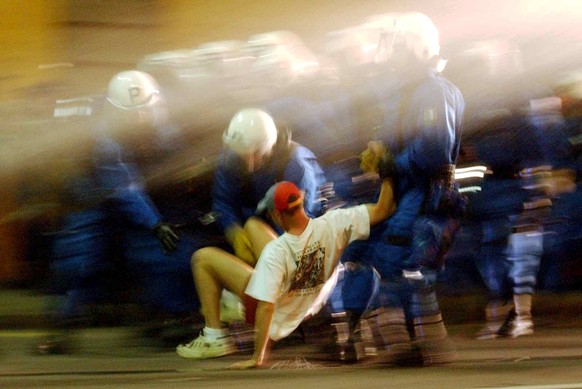 Zurich riot police arrest a protester during a intervention with water cannons in Geneva, Switzerland, Monday night, June 2, 2003. Demonstrators gathered in Lausanne and Geneva over the last days to p ...