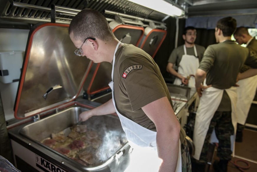 A Swiss army soldier fries meat, pictured on June 12, 2013, on Waffenplatz in Thun, canton of Berne, Switzerland. The mobile kitchen's task is to provide catering on the field. (KEYSTONE/Christia ...