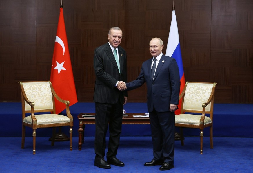 epa10240440 Turkish President Recep Tayyip Erdogan (L) shakes hands with Russian President Vladimir Putin (R) during their meeting on the sidelines of the 6th Summit of the Conference on Interaction a ...