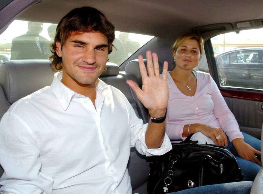 Tennis world number one Roger Federer of Switzerland waves to photographers after he and his girlfriend Mirka Vavrinec (R) arrived at Doha International Airport, Wednesday 29 December 2004. Federer ar ...