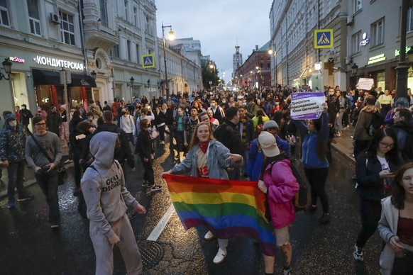 FILE - LGBT activists hold their flag at a rally to collect signatures to cancel the results of voting on amendments to the Constitution in Pushkin Square in Moscow, Russia, Wednesday, July 15, 2020.  ...