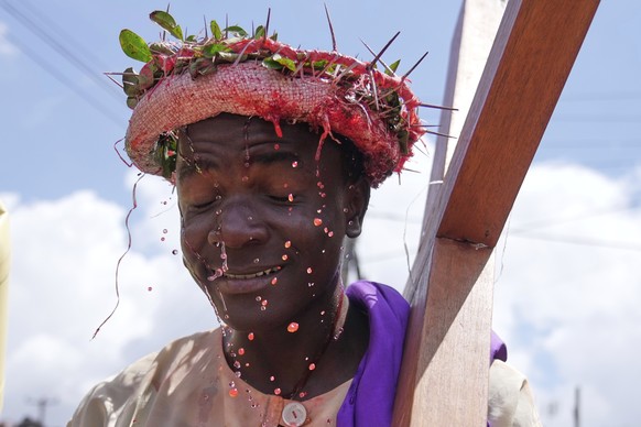 An actor portraying Jesus Christ carries a cross during a Way of the Cross reenactment during Easter Holy Week celebrations in the Kibera area of Nairobi, Kenya, Friday, April 18, 2025. (AP Photo/Bria ...