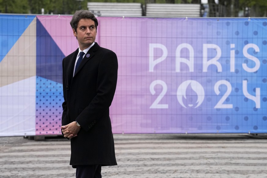 French Prime Minister Gabriel Attal, next to a Paris 2024 Olympic Games sign, attends Victory Day ceremonies, Wednesday, May 8, 2024 in Paris. (AP Photo/Michel Euler, Pool)