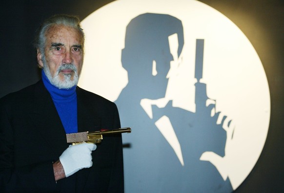 AD004 - 20021015 - LONDON, UNITED KINGDOM : Actor Christopher Lee holds the golden gun beside the Bond logo during the opening of the Bond, James Bond exhibit at The Science Museum in London 15 Octobe ...