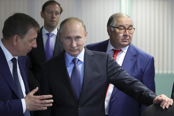 FILE - Russian President Vladimir Putin, center, listens to Lebedinsky GOK Managing Director Oleg Mikhailov, left, as businessman and founder of USM Holdings, Alisher Usmanov, right, and Minister of I ...