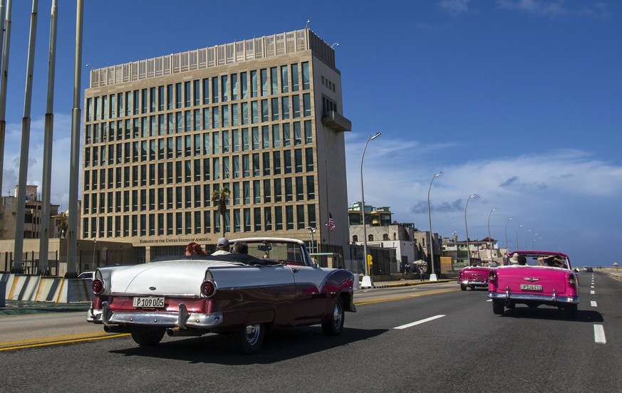 FILE - Tourists ride classic convertible cars on the Malecon beside the United States Embassy in Havana, Cuba, Oct. 3, 2017. The Pentagon confirms that a senior Defense Department official who attende ...