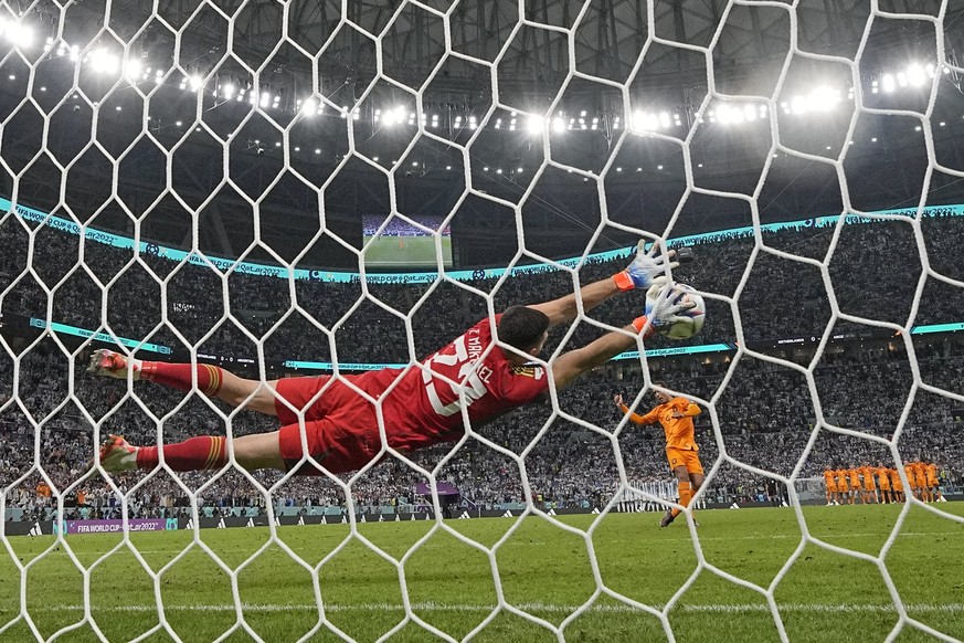 Argentina&#039;s goalkeeper Emiliano Martinez saves from Virgil van Dijk of the Netherlands in a penalty shootout during the World Cup quarterfinal soccer match between the Netherlands and Argentina,  ...