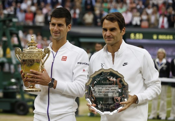 Novak Djokovic of Serbia, left, holds the trophy after winning the men&#039;s singles final against Roger Federer of Switzerland at the All England Lawn Tennis Championships in Wimbledon, London, Sund ...