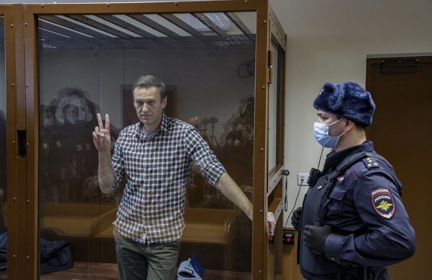 Russian opposition leader Alexei Navalny gestures inside a glass cage prior to a hearing at the Babushkinsky District Court in Moscow, Russia, 20 February 2021.