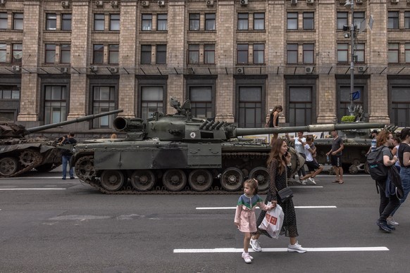 epa10130452 People pass Russian armoured military vehicles that were damaged in fights with the Ukrainian army, displayed on Khreshchatyk street, in downtown Kyiv, ahead of the 'Independence Day& ...