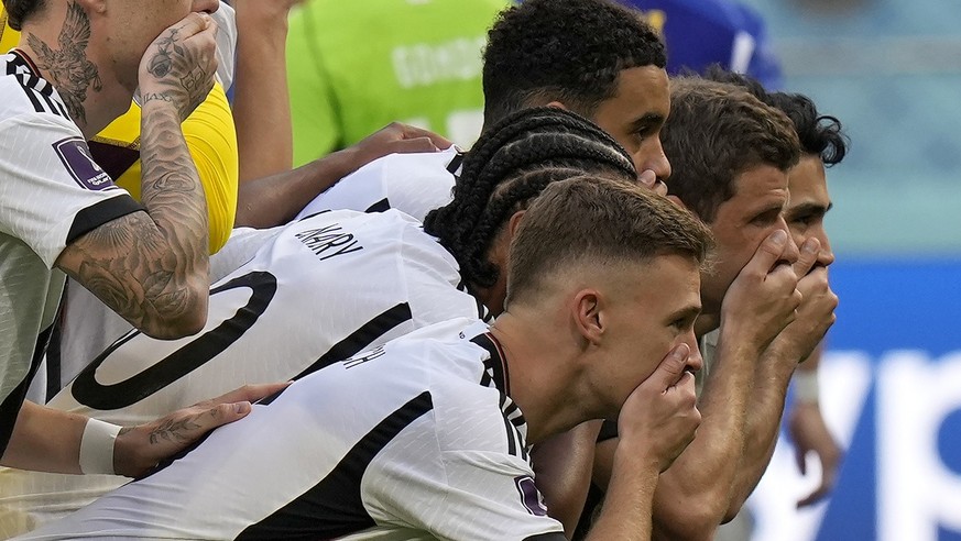 Germany players put their hands on their mouths as they pose for a group photo prior to the World Cup group E soccer match between Germany and Japan, at the Khalifa International Stadium in Doha, Qata ...