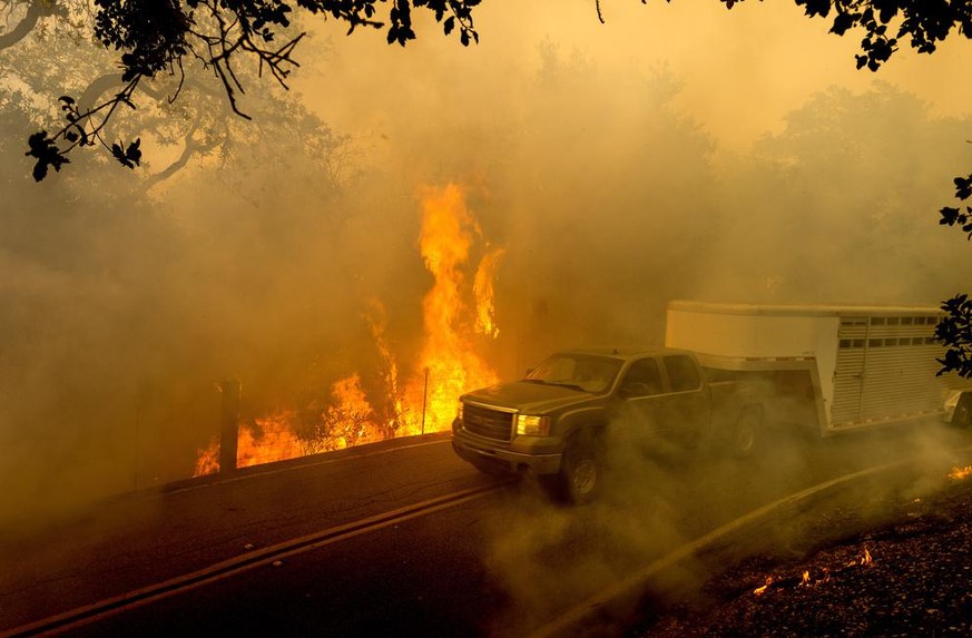 A livestock trailer drives along Canada Road as the Crews Fire burns near Gilroy, Calif., on Sunday, July 5, 2020. (AP Photo/Noah Berger)