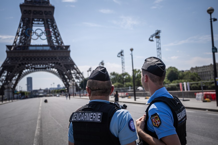 epa11487661 French security forces secure the perimeter in front of the Eiffel Tower that is decorated with the Olympic Rings in Paris, France, 19 July 2024. From 18 to 26 July, the day of the Opening ...