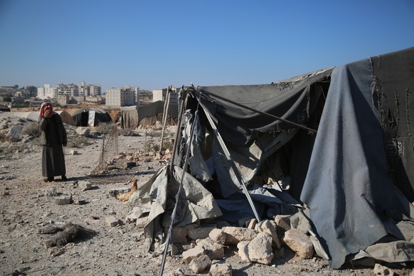 epa11751156 People inspect the damage after an airstrike on a refugee camp in Al-Jame&#039;a neighbourhood in Idlib city, northern Syria, 01 December 2024. According to the White Helmets, the Syrian c ...