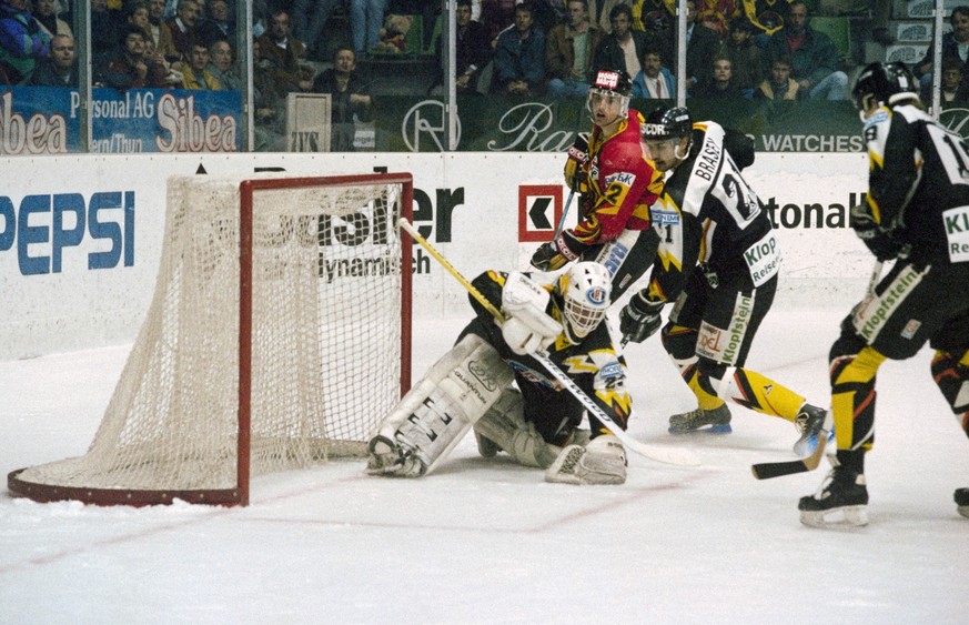 Goalie Dino Stecher, HC Fribourg-Gotteron, abgeschirmt von zwei seiner Verteidigern, haelt den Puck sicher unter Kontrolle, aufgenommen im April 1992 in einem Plyoff Finalspiel gegen den SC Bern im Al ...