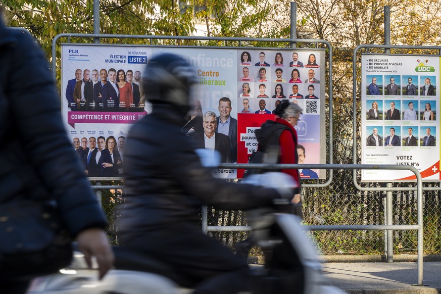 Des personnes passent devant les affiches electorales des differents partis politiques avec leurs candidats en vue du second tour de l'election du Conseil municipales de la ville de Vernier, ce j ...