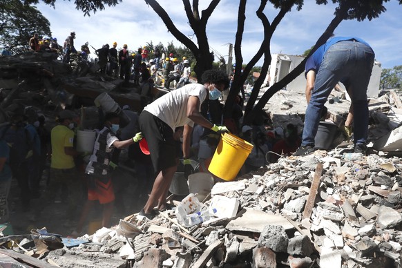 epa13161893 Rescue workers and volunteers take part in a search operation at the scene of a destroyed building following a 7.4-magnitude earthquake, in Cali, Colombia, 11 August 2026. At least 224 peo ...