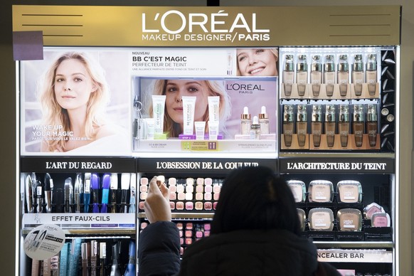 A woman purchases L&#039;Oreal make-up at the Nestle&#039;s own supermarket after the 2019 full-year results press conference of the food and drinks giant Nestle, in Vevey, Switzerland, Thursday, Febr ...