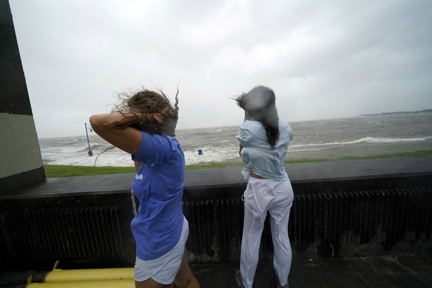 Liliana Arias, left, and Cristina Burgos take photos of the rough waters of Lake Pontchartrain in advance of approaching Hurricane Ida in New Orleans, Sunday, Aug. 29, 2021. (AP Photo/Gerald Herbert)