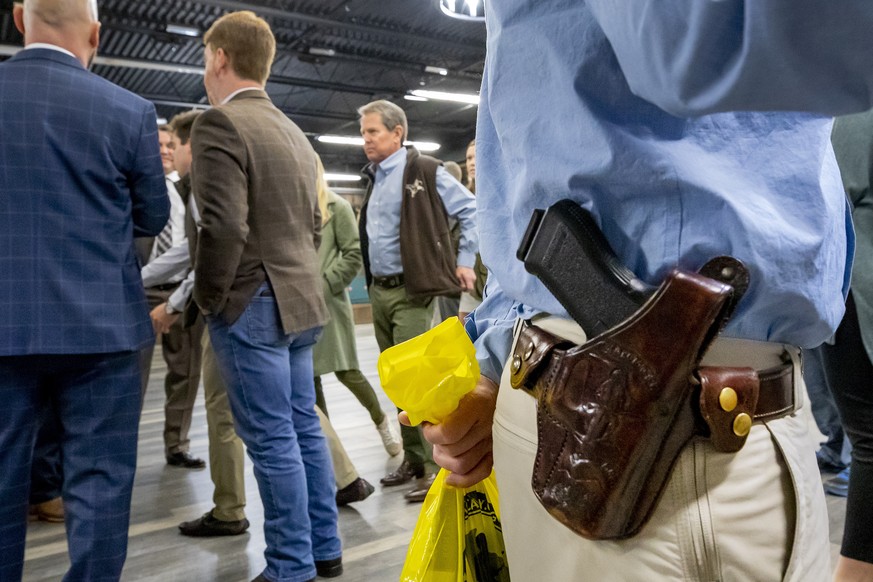 epa09668313 Georgia Republican Governor Brian Kemp (C) participates in a Second Amendment legislation &#039;Constitutional Carry&#039; firearms event at Adventure Outdoors gun store in Smyrna, Georgia ...