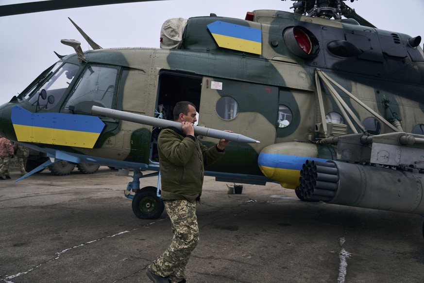 Un soldat charge une arme dans un hélicoptère, sur une base aérienne militaire ukrainienne proche de Kherson.