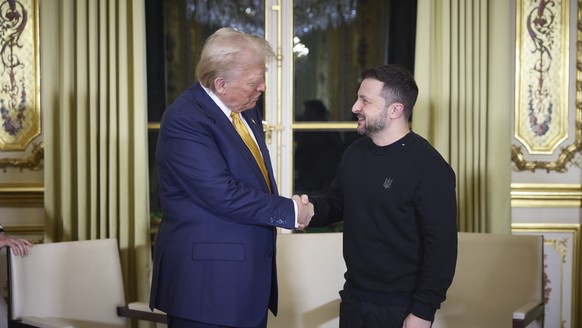 epa11763045 A handout picture made available by the Presidential Press Service of Ukraine shows US President-elect Donald Trump (L), and Ukrainian President Volodymyr Zelensky (R) shaking hands during ...
