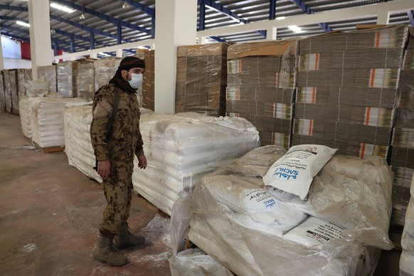 epa11776279 A Syrian rebel fighter stands near raw materials at a factory producing captagon pills, a synthetic amphetamine-type stimulant, prior to the fall of the Bashar al-Assad regime in the city  ...