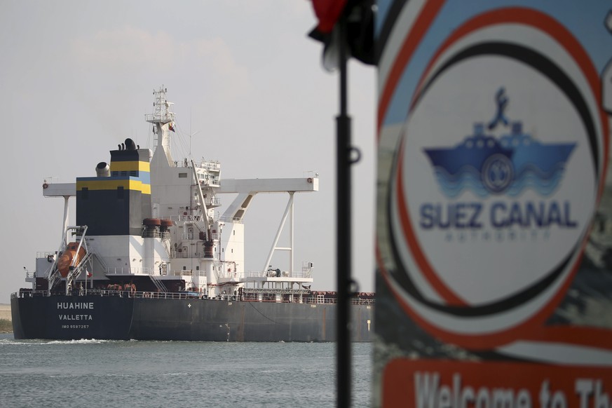 A cargo ship sails through the town of Ismailia, Egypt, Tuesday, March 30, 2021 as traffic resumed through the Suez canal after it was blocked by a massive ship that had been stuck sideways for nearly ...
