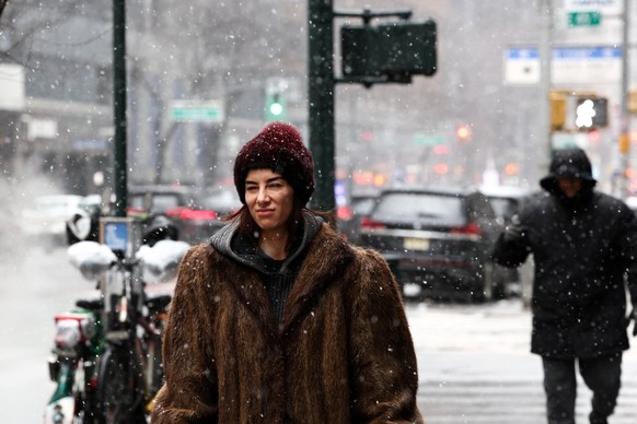 A woman walks along Third Avenue in the Manhattan borough of New York City on February 22, 2026. A fast-developing storm is threatening to pummel the US East Coast with a foot (30cm) or more of snow b ...