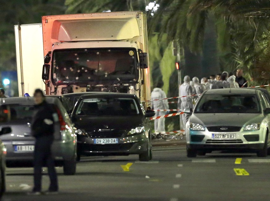 FILE - In this July 15, 2016, file photo, forensic officers stand near a truck with its windscreen riddled with bullets that plowed through a crowd of revelers who&#039;d gathered to watch the firewor ...