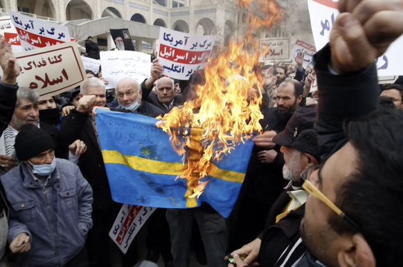 Les Iraniens brûlent le drapeau du pays en réponse à l&#039;incendie du Coran en Suède.