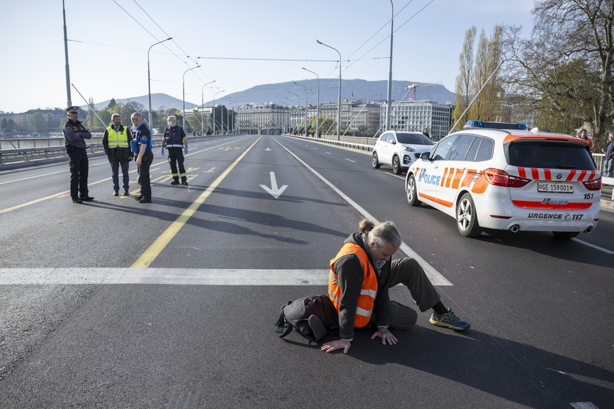 Climate activist sit down in the road during the &quot;Renovate Switzerland&quot; a roadblock action at the Mont-Blanc bridge is a road bridge over the Rhone, in Geneva, Switzerland, Friday, 14 April, ...