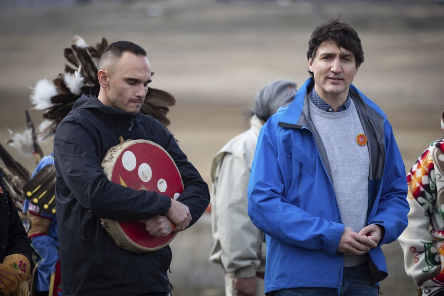 Prime Minister Justin Trudeau speaks as Williams Lake First Nation Chief Willie Sellars, left, listens during a visit to the former grounds of St. Joseph&#039;s Mission Residential School, in Williams ...
