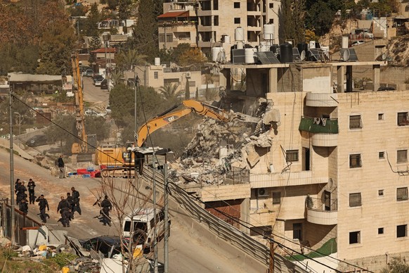 Israeli security forces gather as excavators demolish a building constructed without a permit in the Wadi Qaddum area near the Silwan neighbourhood of east Jerusalem on December 22, 2025. Israeli bull ...