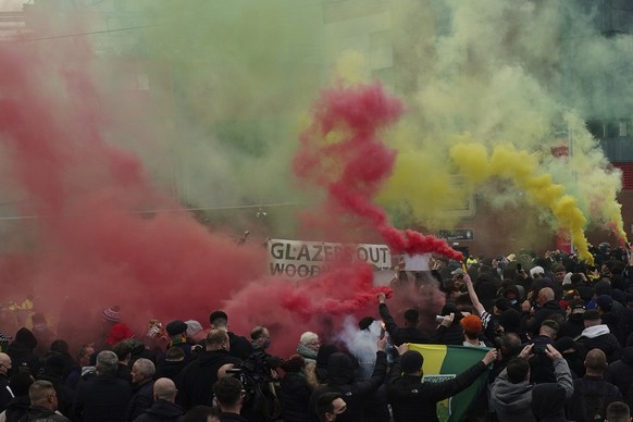 Manchester United fans let off flares as they protest against the Glazer family, the American owners of Manchester United, before their English Premier League soccer match against Liverpool at Old Tra ...