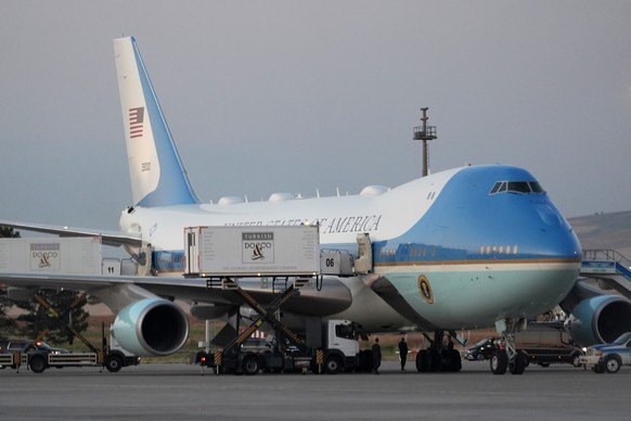 FILE - Catering trucks are parked at Air Force One on the tarmac as the motorcade carrying U.S. President Donald Trump arrives on the tarmac to depart following the NATO summit at Ankara International ...