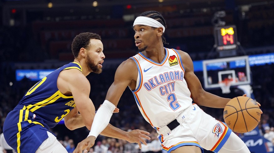 Oklahoma City Thunder guard Shai Gilgeous-Alexander (2) spins around Golden State Warriors guard Stephen Curry during the first half of an NBA basketball game Friday, Dec. 8, 2023, in Oklahoma City. ( ...