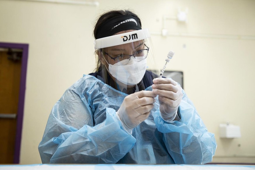 epa09460608 A nurse prepares doses of the Pfizer Covid-19 vaccine at a middle school in Los Angeles, California, USA, 10 September 2021. Los Angeles Unified School District (LAUSD) approved on 09 Sept ...