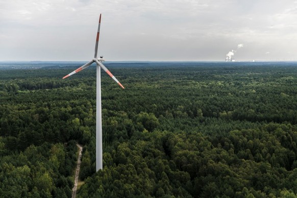 BERNSDORF, GERMANY - AUGUST 04: A wind power station in the middle of a forest and the brown coal power station of Boxberg are pictured on August 04, 2017 in Bernsdorf, Germany. (Photo by Florian Gaer ...