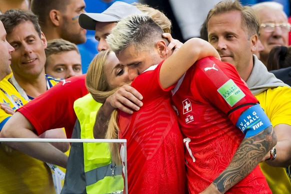 Switzerland&#039;s soccer player Valon Behrami, right, kisses his gilfriend ski racer Lara Gut of Switzerland, left, during the FIFA World Cup 2018 round of 16 soccer match between Sweden and Switzerl ...